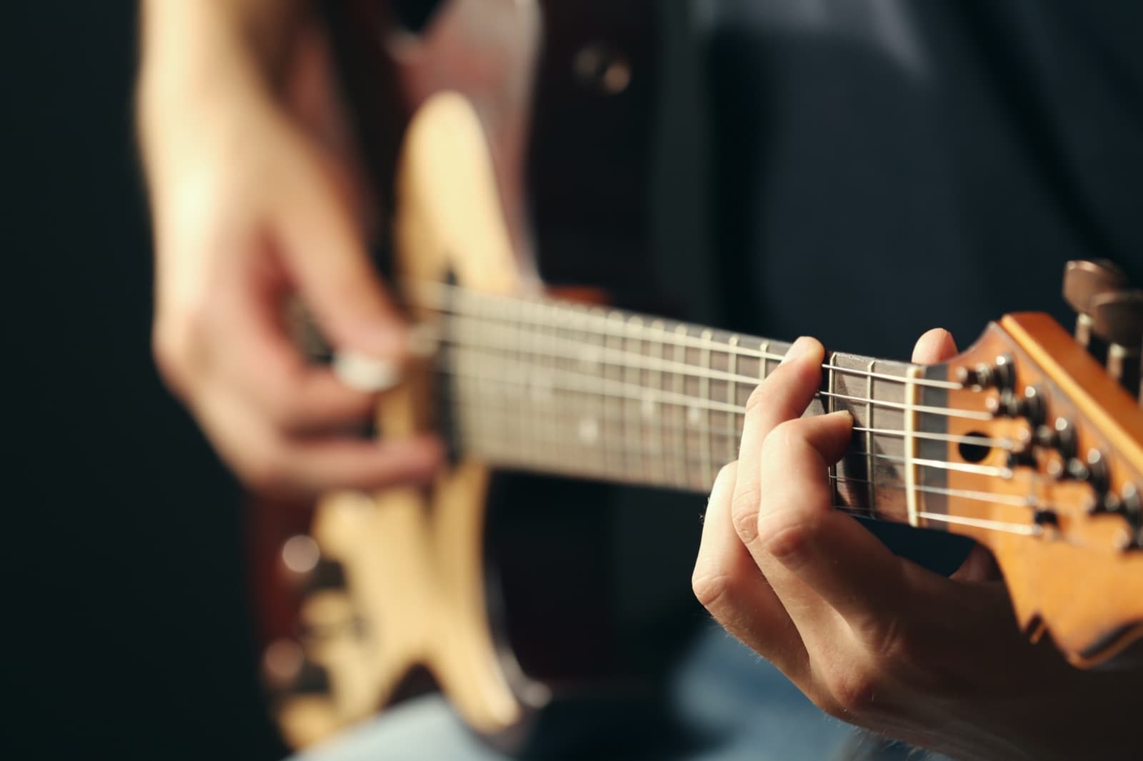 Muzyk gra na gitarze - zbliżenie na gryf